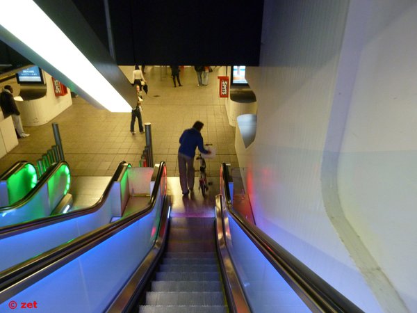 Человек с велосипедом подмышкой спускается на платформу станции метро Centraal Station