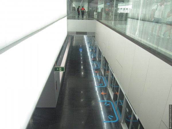 Станция Aeroport T2. Подземная, неглубокого заложения. Со второго этажа станции можно посмотреть на платформу, куда прибывают поезда.